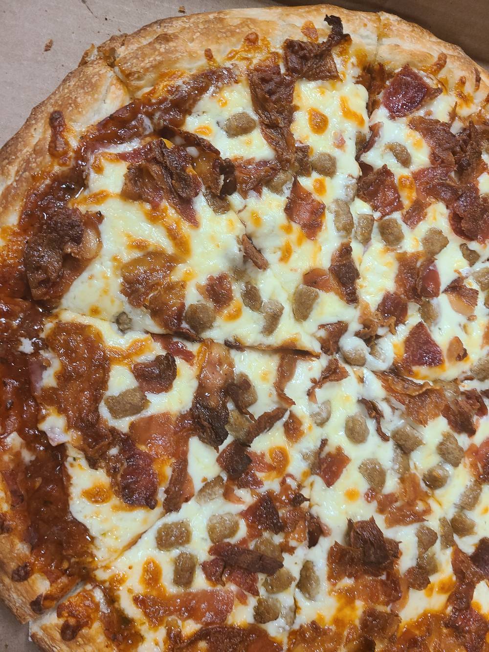 Meat Man pizza covered in ham, salami, bacon and pepperoni.